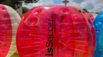 Colorful inflatable balls on grass field.
