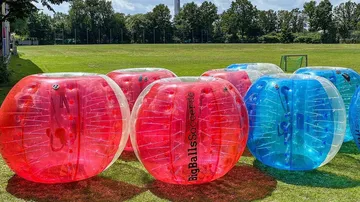 Large inflatable balls on grass field.