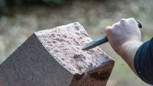 Hand meißelt Steinblock im Freien (c) Bastian Rakow, Rochlitz