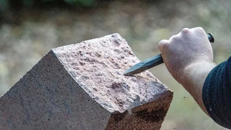 Hand meißelt Steinblock im Freien (c) Bastian Rakow, Rochlitz