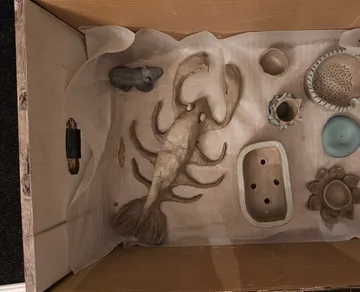 Tonfiguren in einem Karton.