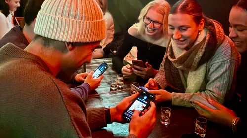 Group of people at a table using smartphones.