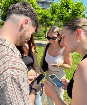 Gruppe von Personen nutzt Smartphones im Freien.