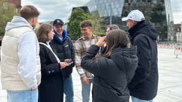 Group of six people talking outdoors.