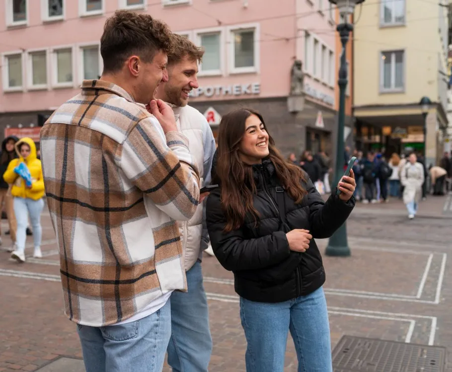 Group taking selfie on busy city street.