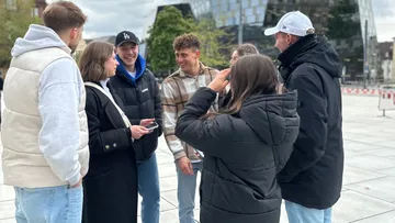 Group of people talking outside a modern building.
