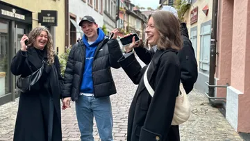 People laughing on a cobblestone street.