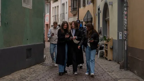 Group of friends walking in narrow street.