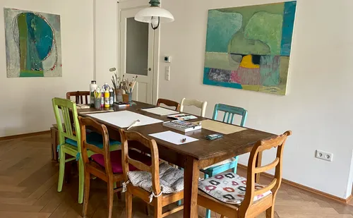 Dining table with art supplies in a cozy room.