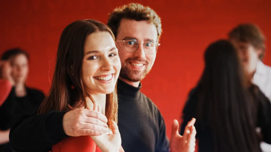 Smiling couple dancing in a red room.