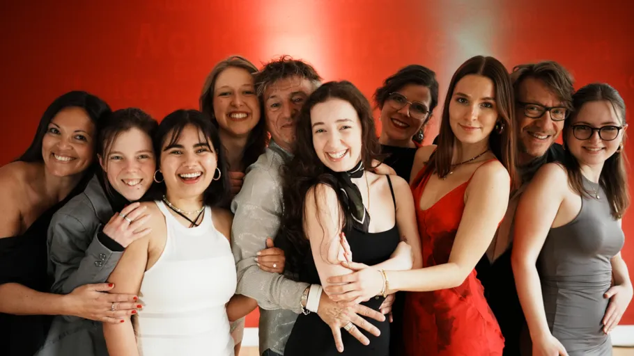Group of people smiling, standing in a line.
