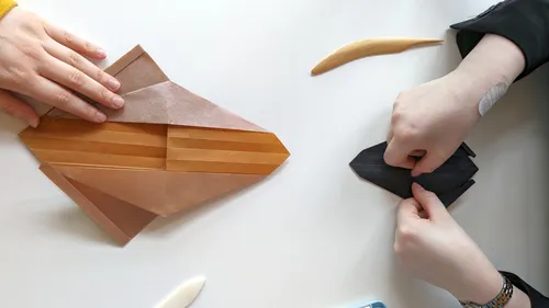 People folding origami on a table.