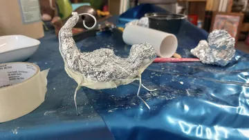 Aluminum foil sculpture on table in art studio.