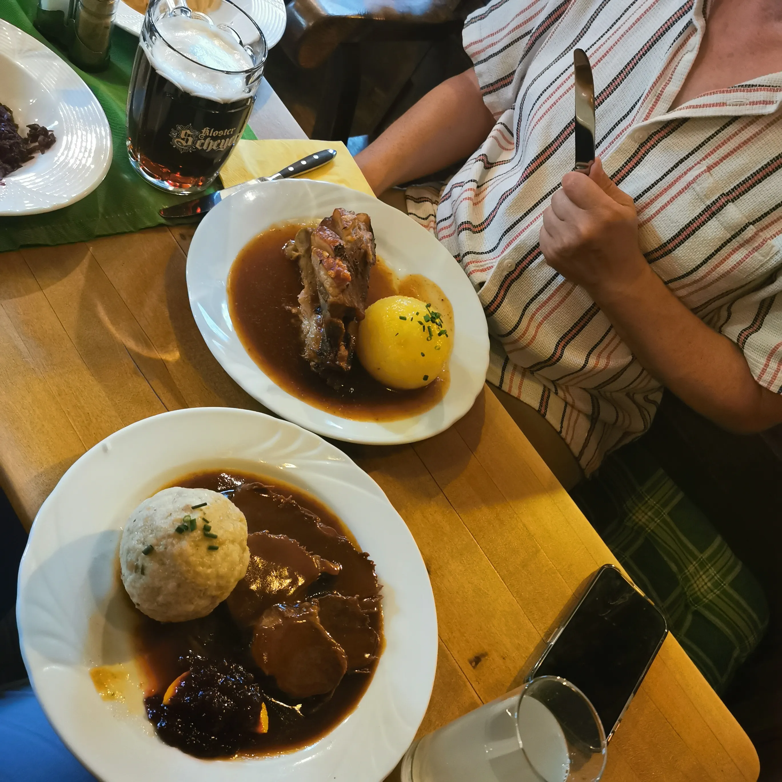 Person beim Essen deutscher Gerichte, hält Messer.