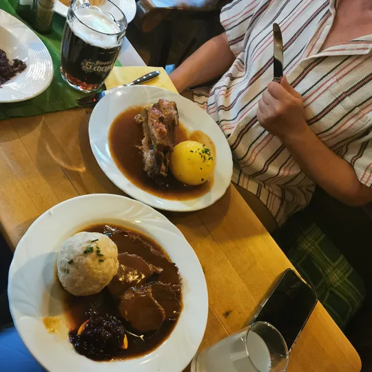 Person beim Essen deutscher Gerichte, hält Messer.