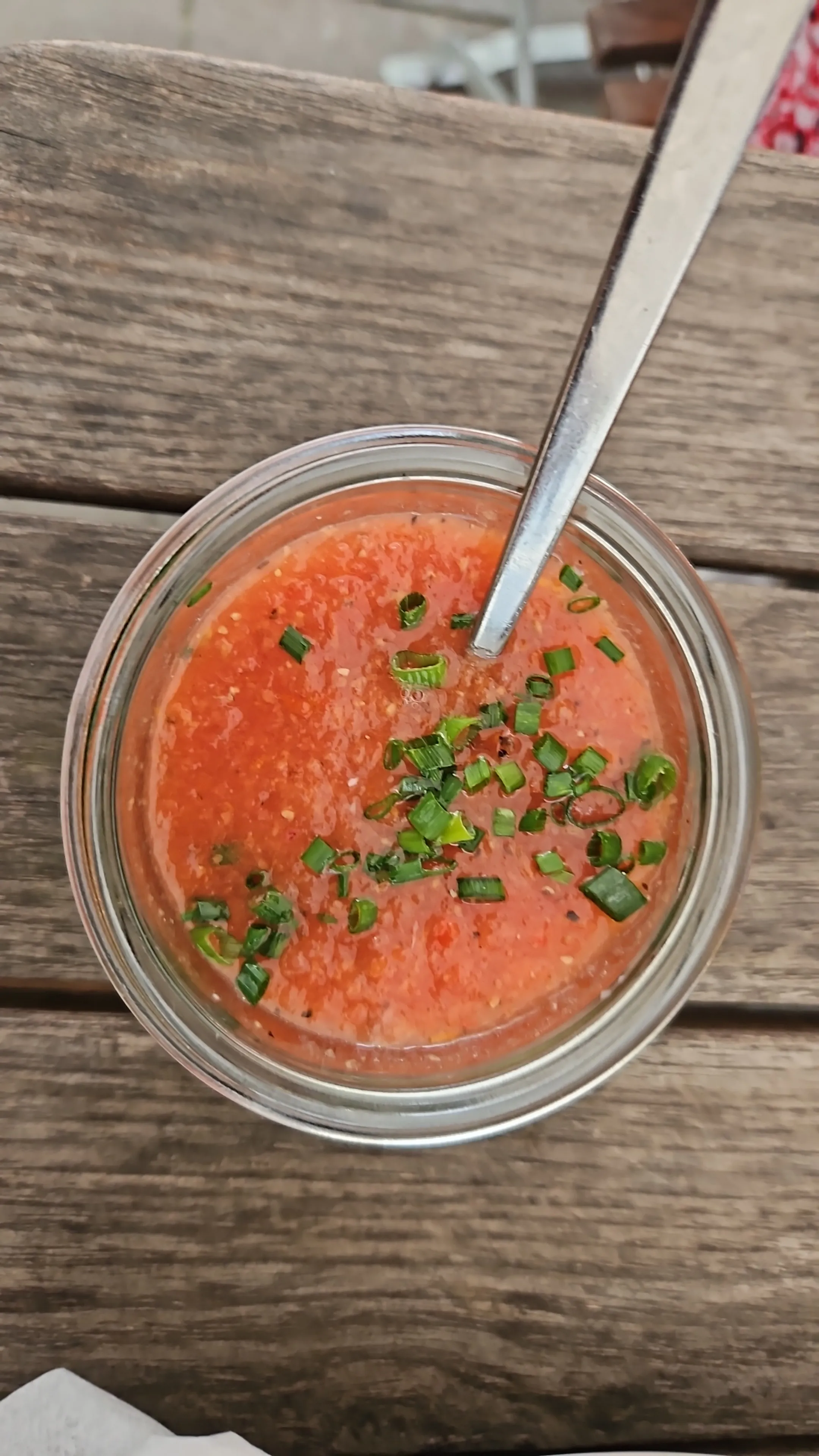 Gazpacho mit Schnittlauch in Glas auf Tisch.
