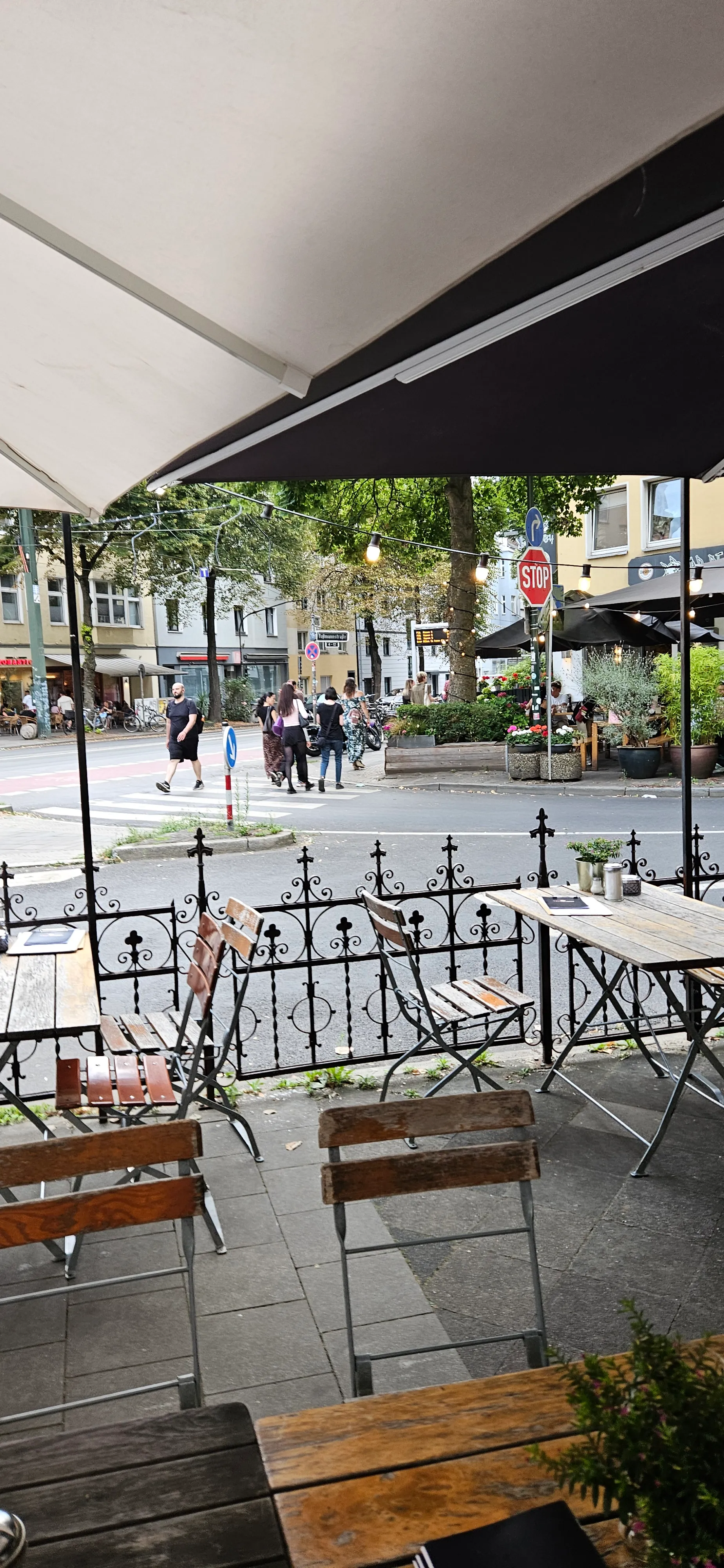 Sicht auf Straßencafé mit Straße und Fußgängern.