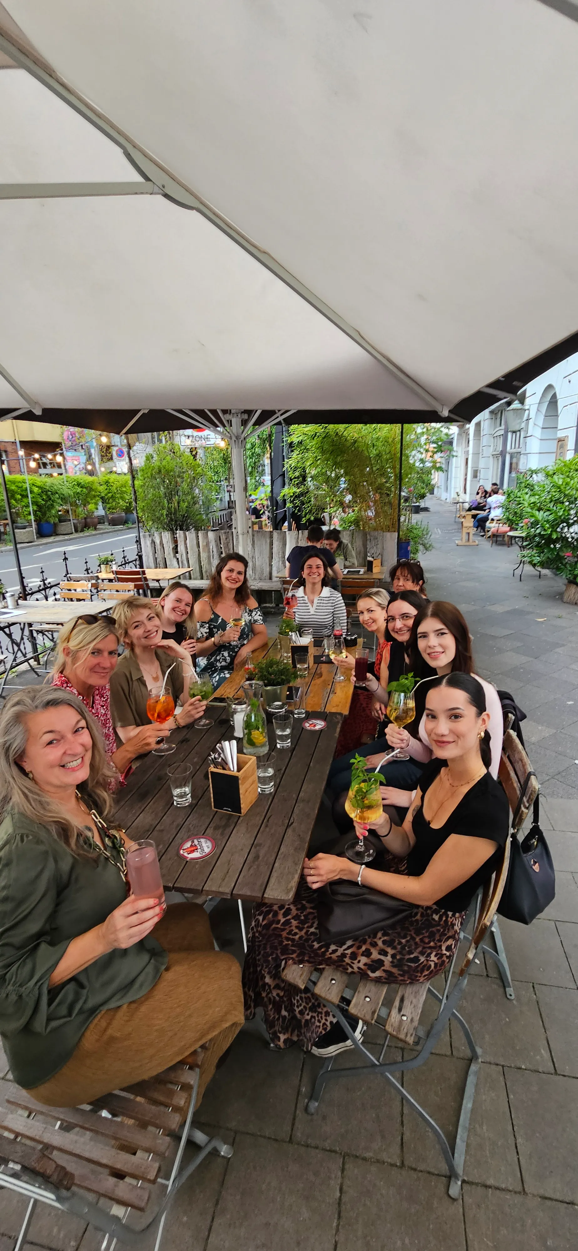 Gruppe von Leuten genießt Getränke im Freien Café.