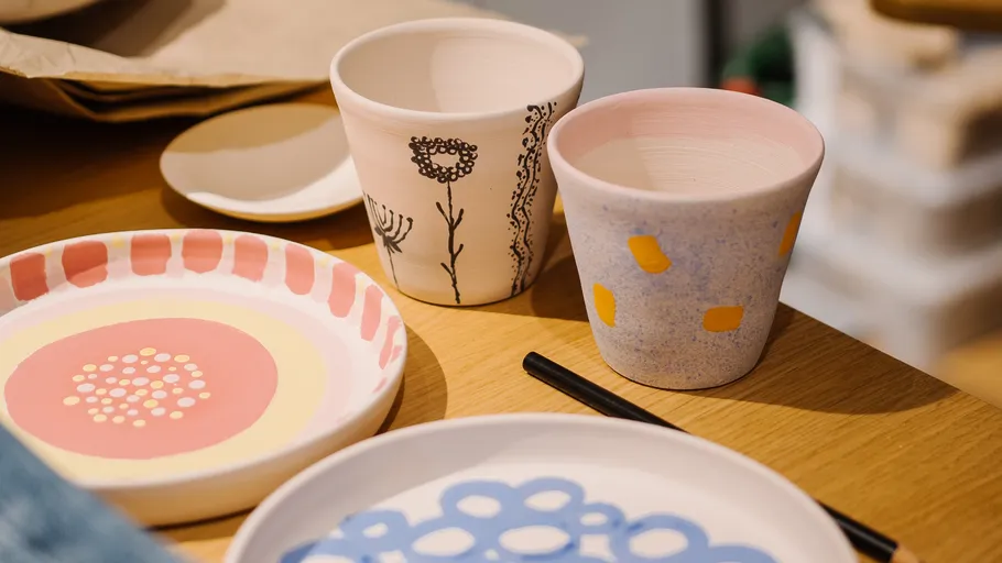 Colorful ceramics on wooden table, artistic designs.