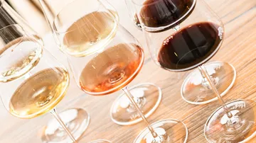 Vier Weingläser mit verschiedenen Weinen gefüllt.