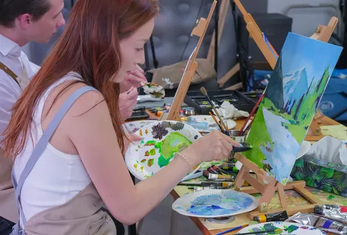Woman painting landscape in art class.