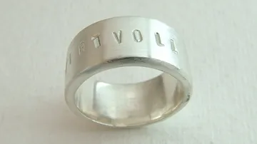 Silver ring with engraved word 'WERTVOLL'.