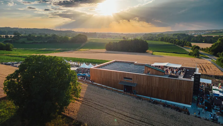 Großes Holzgebäude in ländlicher Landschaft.