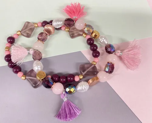 Colorful bead bracelets with tassels on paper.