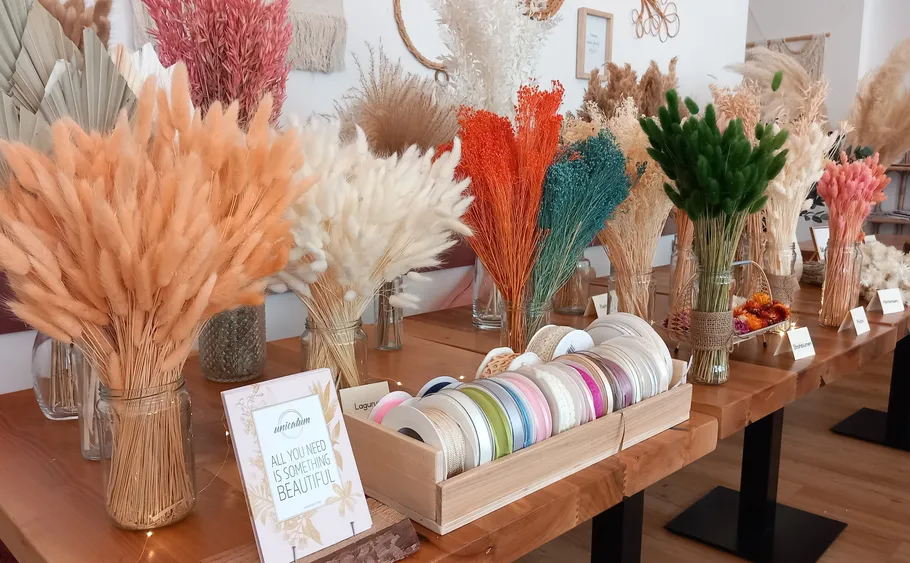 Bunte Trockenblumen auf Holztisch ausgestellt.
