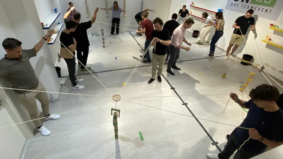 People stand holding ropes in a room.