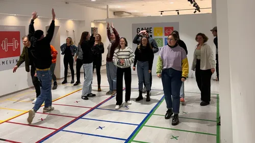 People playing indoor game on marked floor.