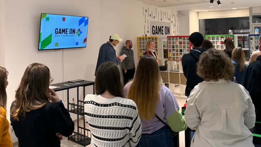 People watching presentation in a game-themed room.