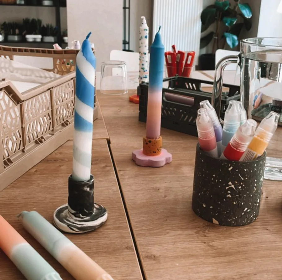 Bunte Kerzen und Stifte auf Holztisch.