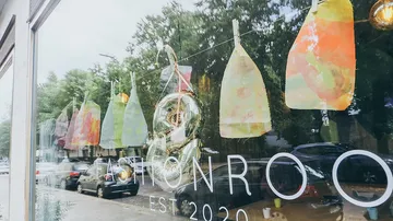 Storefront with colorful artwork and reflection.