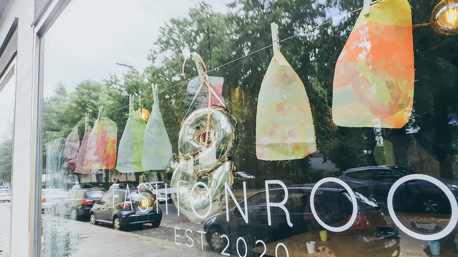 Schaufenster mit bunter Kunst und Spiegelung.