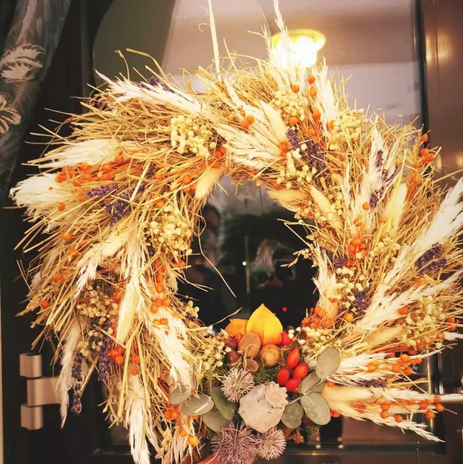 Decorative wreath with dried plants on door.