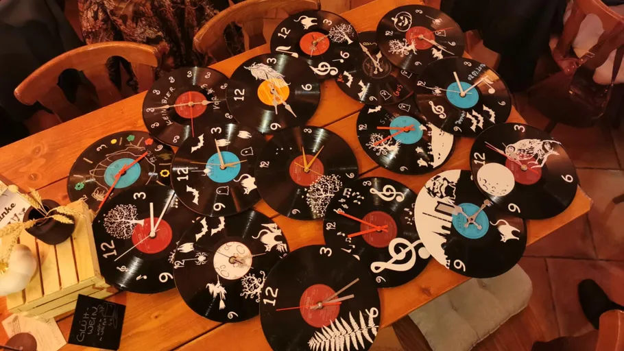 Vinyl-Schallplatten-Uhren auf Holztisch ausgestellt.