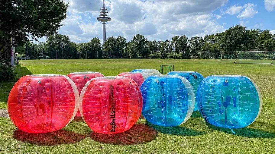 Inflatable balls on grass in outdoor park.