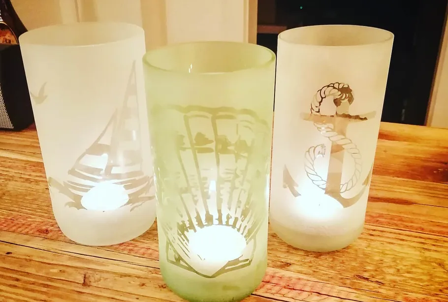 Decorative frosted glass candle holders on wooden table.