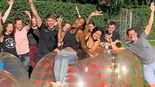 Group joyfully posing with inflatable balls outside.
