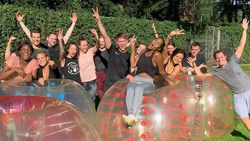 Gruppe von Menschen posiert mit aufblasbaren Bumpern im Freien.