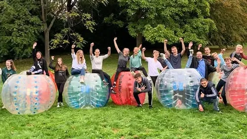 Group sitting on inflatable balls in a park.