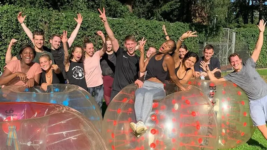 Group of people celebrating with inflatable balls outdoors.