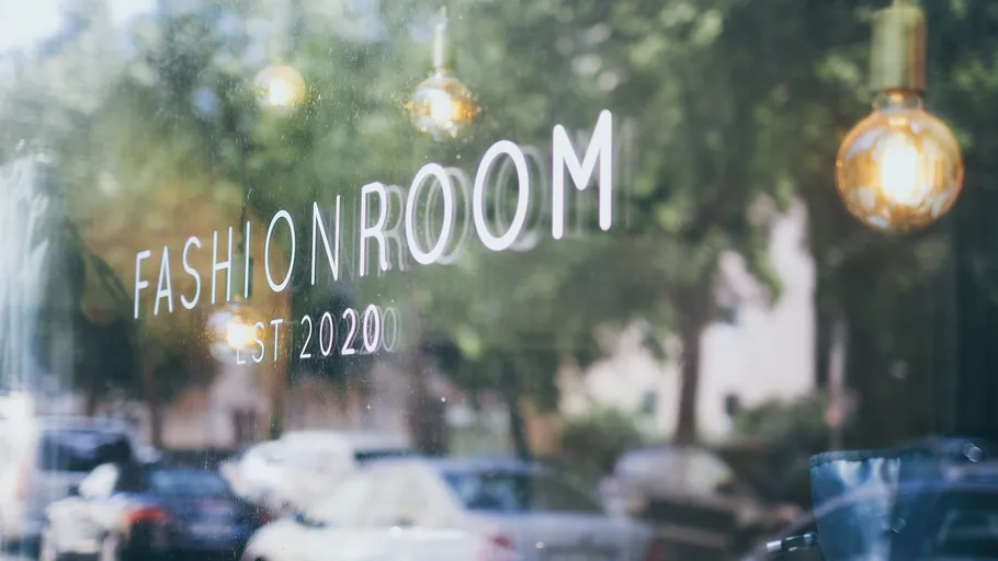 Schaufenster mit 'Fashion Room' Text, Straßenansicht.