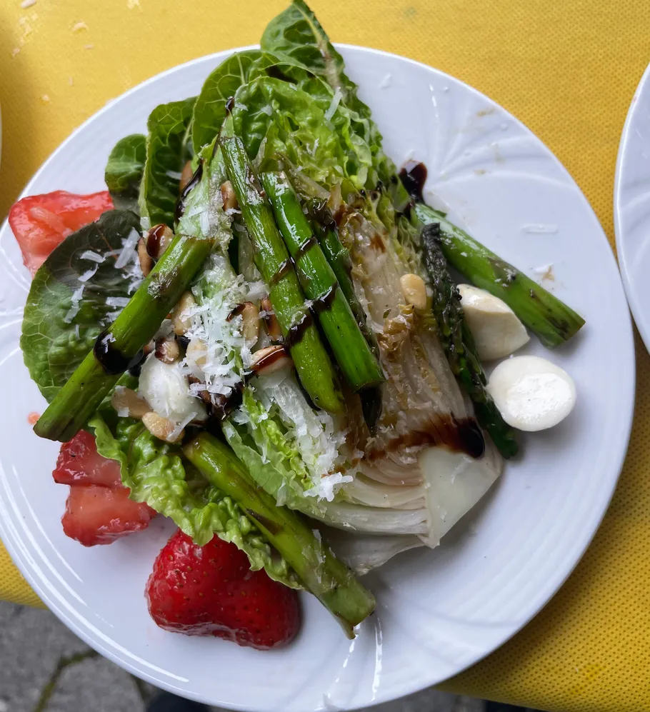 Salad with asparagus and strawberries, outdoors.