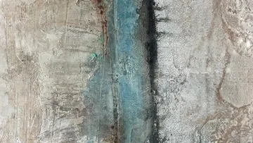 Abstrakte Wandstruktur mit Blau- und Grautönen.