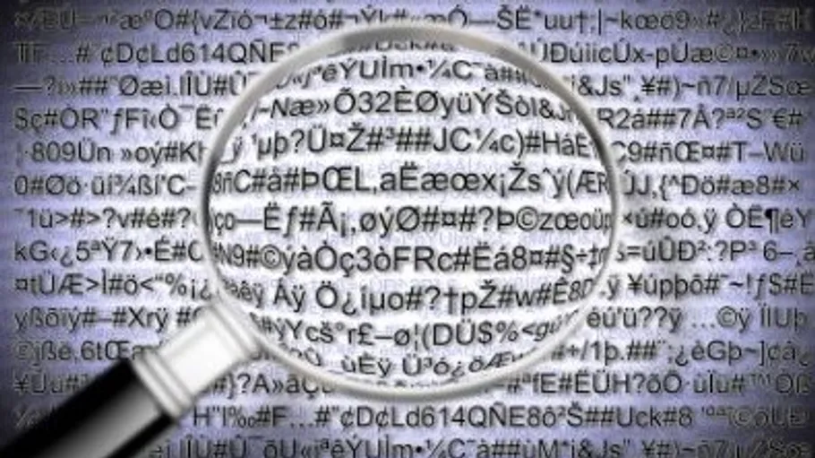 Magnifying glass over jumbled text on screen.