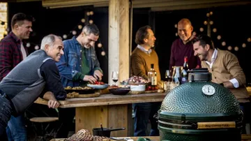 Group of men enjoying barbecue outside.