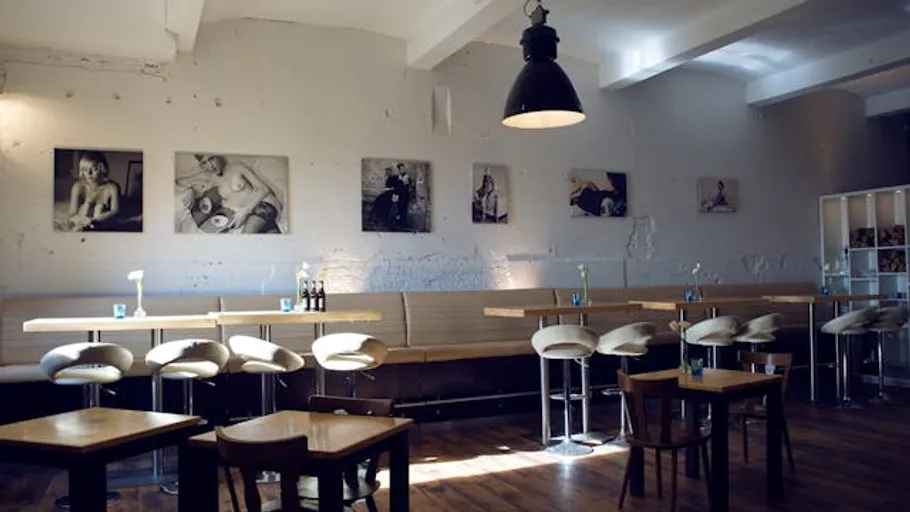 Modernes Café mit Wandkunst und Möbeln.