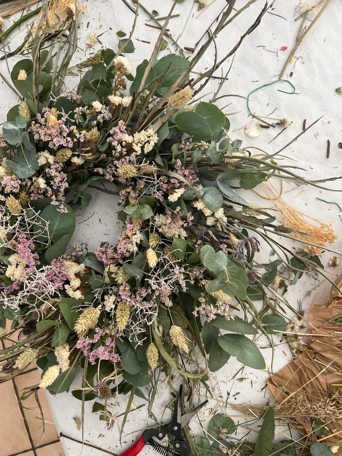 Blumenkranz auf unordentlichem Basteltisch.